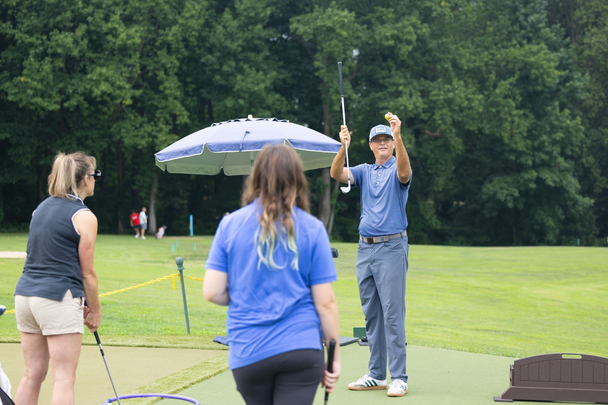 A coach demonstrating a drill to a small group of beginners